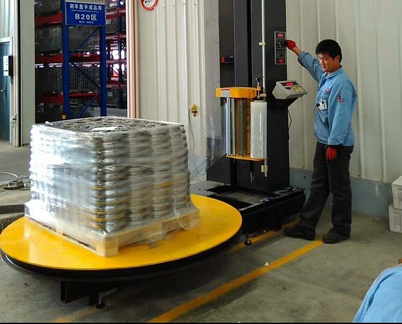 Man wrapping pallet on machine
